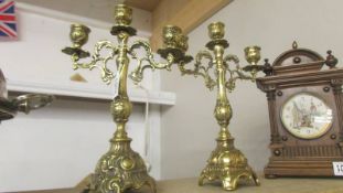 A pair of ornate brass candelabra.