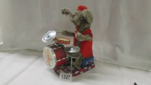 A battery operated elephant playing drums.