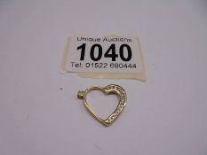 A gold heart pendant, 1.8 grams.