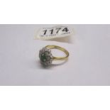 An 18ct gold ring set 8 diamonds and an emerald, size P, 5 grams.