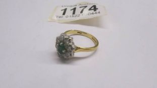 An 18ct gold ring set 8 diamonds and an emerald, size P, 5 grams.