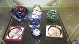 Seven good glass paperweights including two souvenir.
