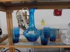 A blue glass jug and five tumblers.