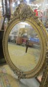 A large oval bevel edged mirror in gilded frame. COLLECT ONLY.