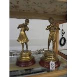 A pair of brass musician figures.