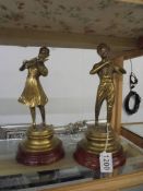 A pair of brass musician figures.