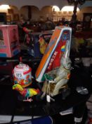 A boxed tin plate elephant on bike (missing ball) a tin plate music box & 1 other