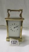 A brass carriage clock with key.