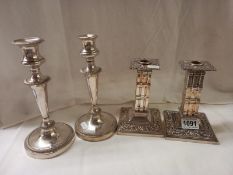 Two pairs of silver plate candlesticks.