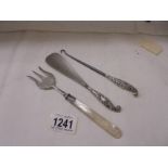 A silver fork with mother of pearl handle together with a silver handled shoe horn and button hook.