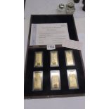 A cased set of six gold plated pound ingots with certificate.