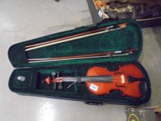 A cased 'Tunes' violin with two bows.