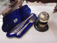 A cased pair of fish servers and a bowling trophy.