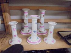 Two pairs and a single ceramic candlesticks.