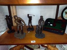 4 golf related figures and a cased as new putter with balls