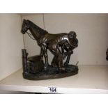 A silvered resin blacksmith with horse resin figure group