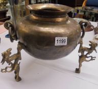 A large oriental brass pot on three Dragon feet.