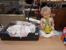 A vintage doll & a box of doll's clothes