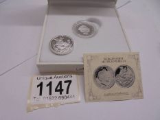 A cased World's first silver sovereign and an un-cased example.