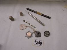 A mixed lot including silver fobs, silver badge, silver thimbles etc.,