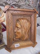 A carved wood plaque depicting the head of Christ.