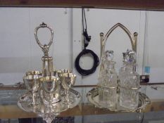 A four bottle cruet and an egg cup stand with spoons.