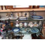 Three shelves of ceramics including Chinese plates.