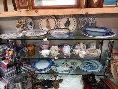 Three shelves of ceramics including Chinese plates.