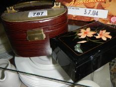 A lacquered jewellery box and a vanity case.