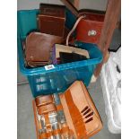 A crate containing a leather camera case and other boxes.