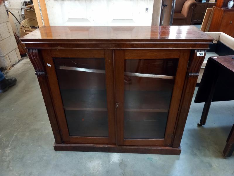 A Victorian mahogany veneered glazed bookcase. 107 cm x 34cm x height 97cm.