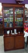 A dark wood stained wall unit with cut glass doors (45cm x 92 cm x 196 cm high). Collect Only.