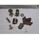 A quantity of cap badges, cloth badges and three compasses.