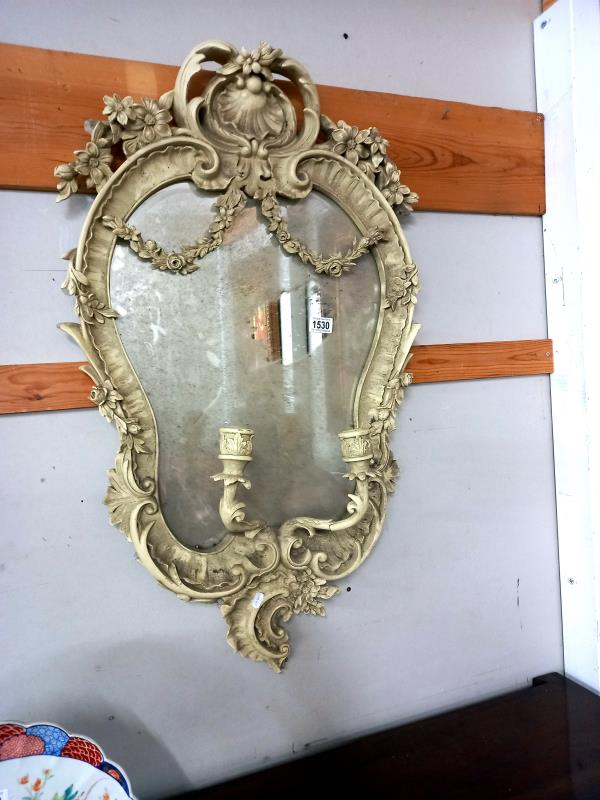 A large white ormolu framed mirror with candle holders. 57cm x 97cm.