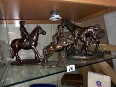 A silvered resin blacksmith with horse resin figure group, 2 resin horse and rider figures, 1