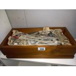 A wooden box containing old clay pipes.