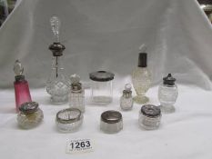 11 various glass bottles and jars with silver tops/rims.