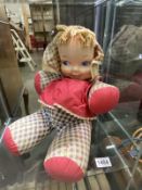 A large vintage rag doll with celluloid.