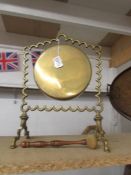 A brass dinner gong with hammer.