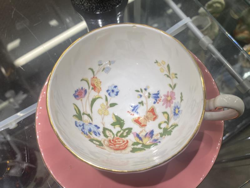 An Aynsley pink cup and saucer, butterfly garden design in cup. (Small chip near the rim of the - Image 2 of 4
