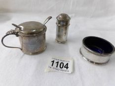 A silver hall marked salt, pepper and mustard pots with blue liners.