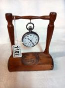 A Longines Gentleman's pocket watch in working order on a wooden watch stand.