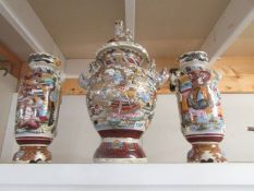 A three piece Chinese ceramic garniture of lidded vase and pair of side vases.