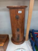 A round teak 3 drawer chest. Height 61cm, top diameter 29 cm. Collect Only.