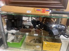 A collection of cameras, photographic accessories and binoculars.