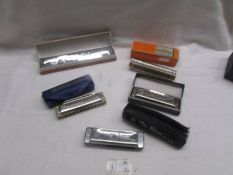 Three Hohner harmonica's and two others.