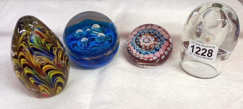 A millifiori glass paperweight and three others.