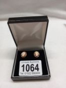A pair of 9ct gold vintage cameo stud earrings with a fancy gold work mount.