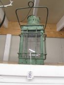 A green painted metal candle lantern.