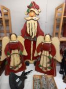 A wooden Santa Claus, approximately 100cm tall. 2 wooden Angels, approximately 60cm tall.